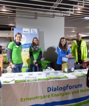 Messestand des Dialogforum Energiewende und Naturschutz mit vier Mitarbeiter*innen